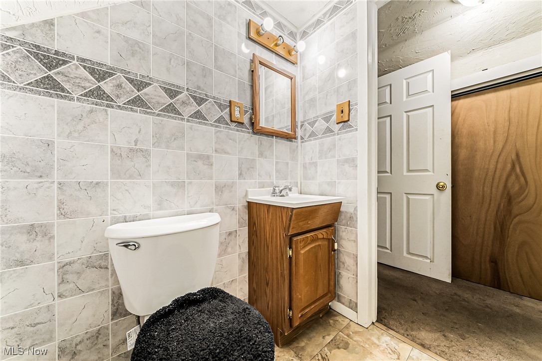 2014 Cook Avenue Cleveland, OH 44109 - Photo 25 of 37 Bathroom featuring vanity, tile walls, and toilet