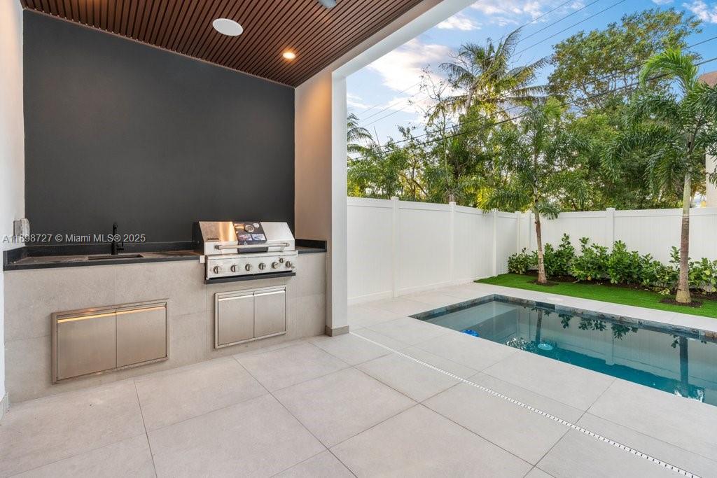 1215 Northeast 11th Avenue, Unit B Fort Lauderdale, FL 33304 - Photo 20 of 62 a kitchen with stainless steel appliances kitchen island granite countertop a sink and a stove