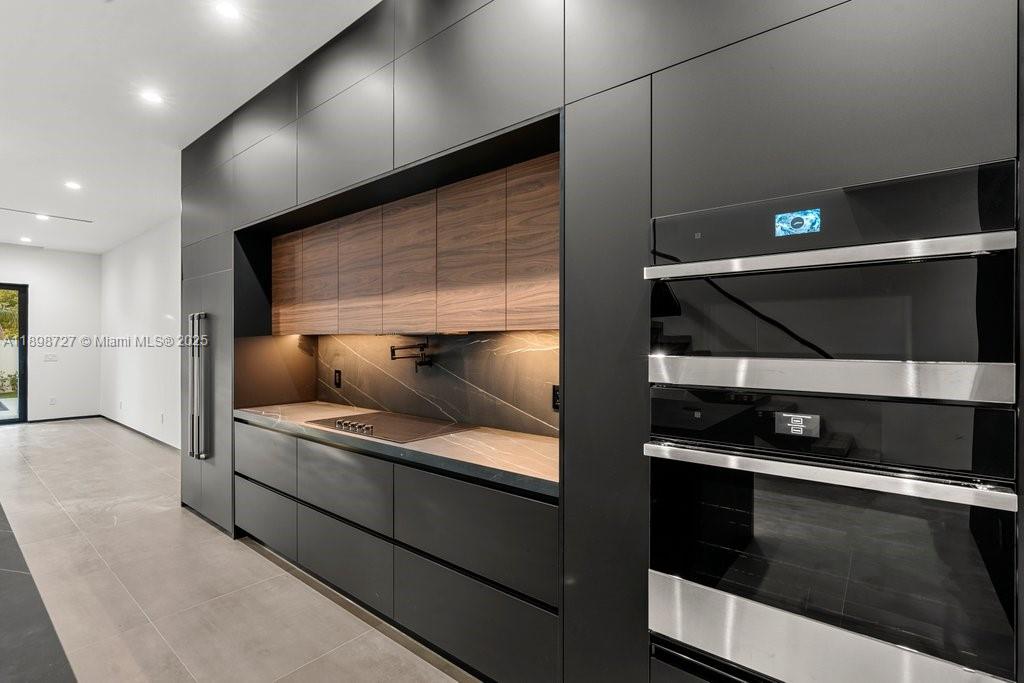 1215 Northeast 11th Avenue, Unit B Fort Lauderdale, FL 33304 - Photo 38 of 62 a kitchen with stainless steel appliances kitchen island granite countertop a stove and a microwave