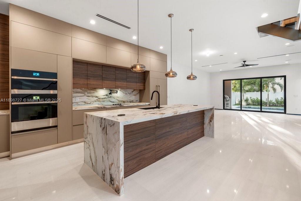1215 Northeast 11th Avenue, Unit B Fort Lauderdale, FL 33304 - Photo 9 of 62 a large white kitchen with a large counter top a stove a sink and a refrigerator