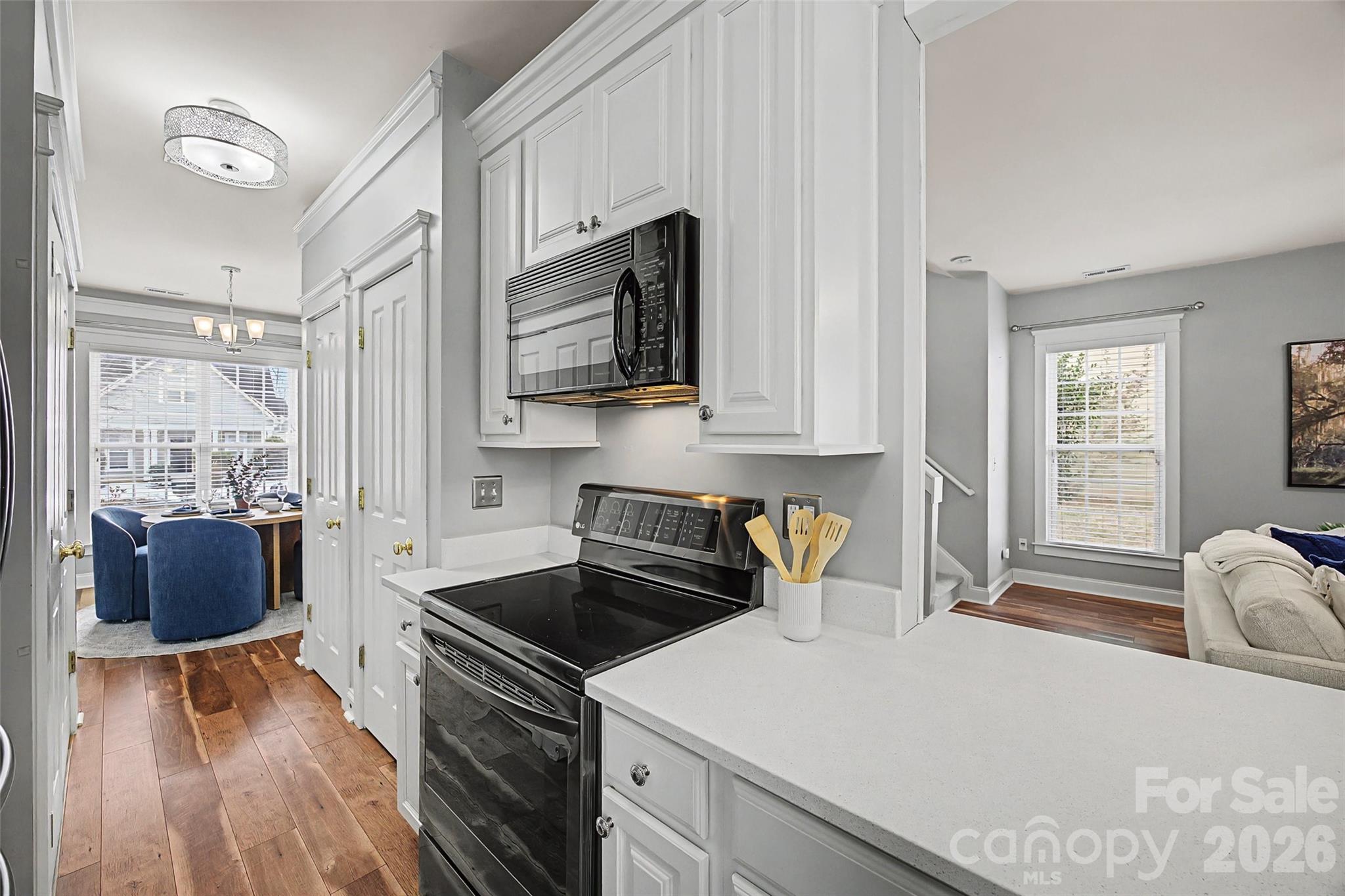 8123 Bud Henderson Road Huntersville, NC 28078 - Photo 11 of 48 a kitchen with stainless steel appliances a stove a microwave a sink and cabinets