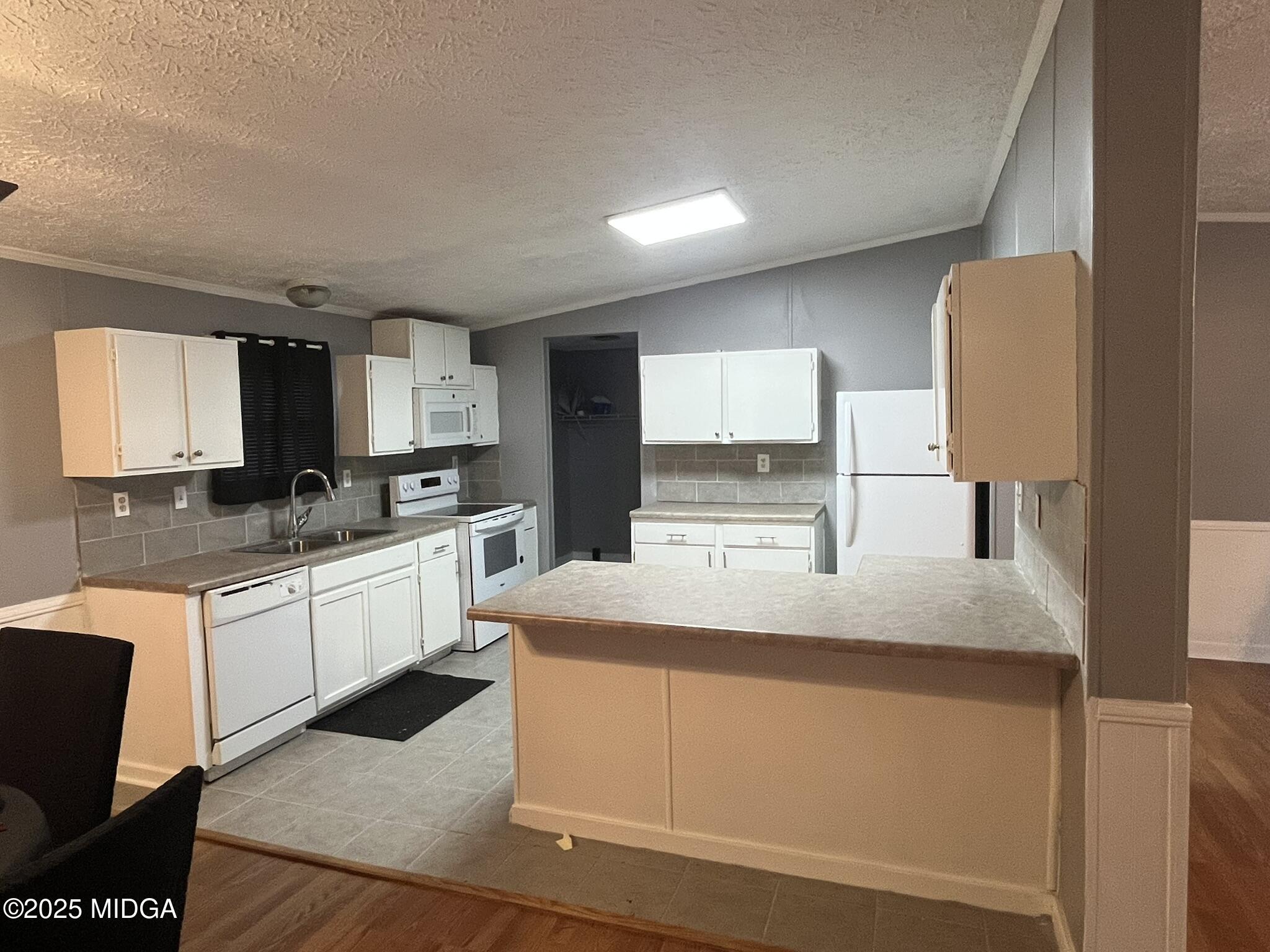 111 Mandy Court Macon, GA 31217 - Photo 6 of 12 a kitchen with kitchen island granite countertop a sink a stove a refrigerator and cabinets