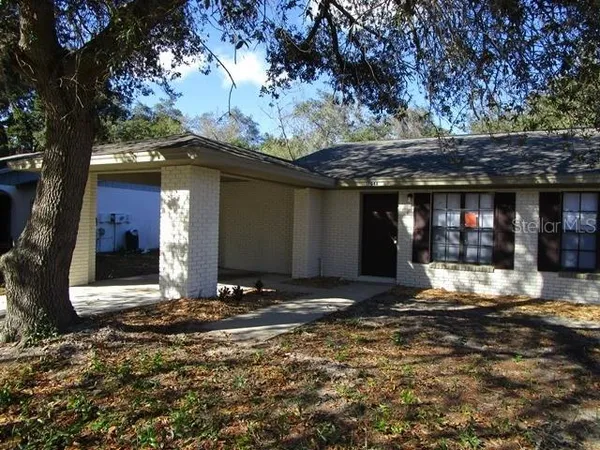 a view of a house with large tree and wooden fence