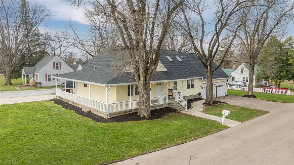8240 Looney Road Piqua, OH 45356 - Photo 4 of 49 This inviting home offers classic appeal with a welcoming front porch, perfect for enjoying quiet mornings.