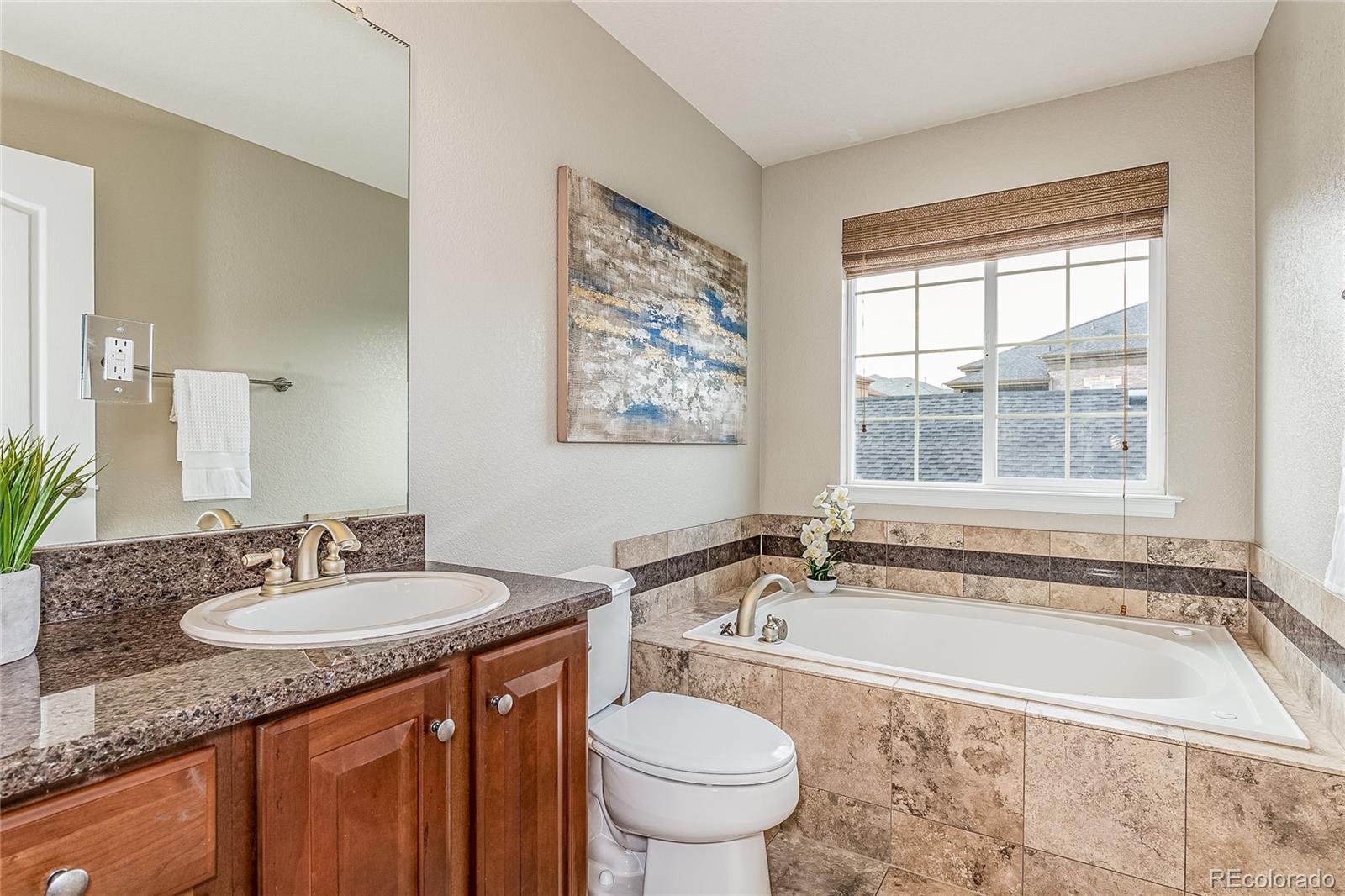 592 Brookhurst Avenue, Unit 26B Highlands Ranch, CO 80129 - Photo 15 of 19 a bathroom with a granite countertop sink and a bathtub