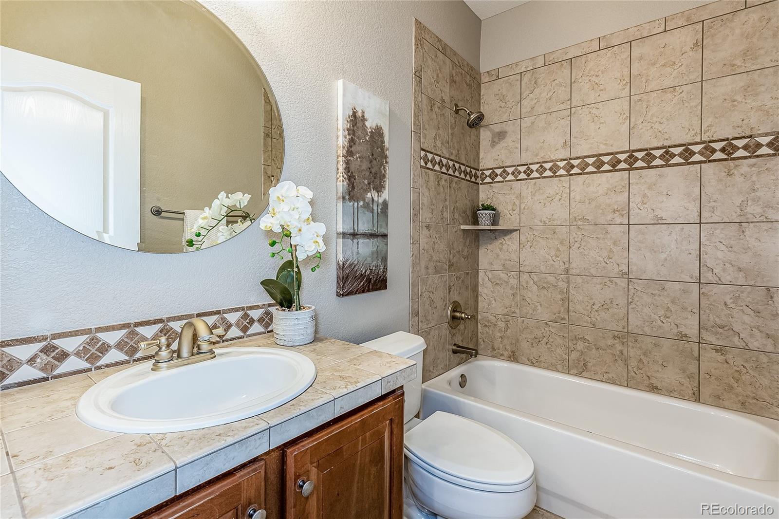 592 Brookhurst Avenue, Unit 26B Highlands Ranch, CO 80129 - Photo 19 of 19 a bathroom with a granite countertop sink toilet and shower