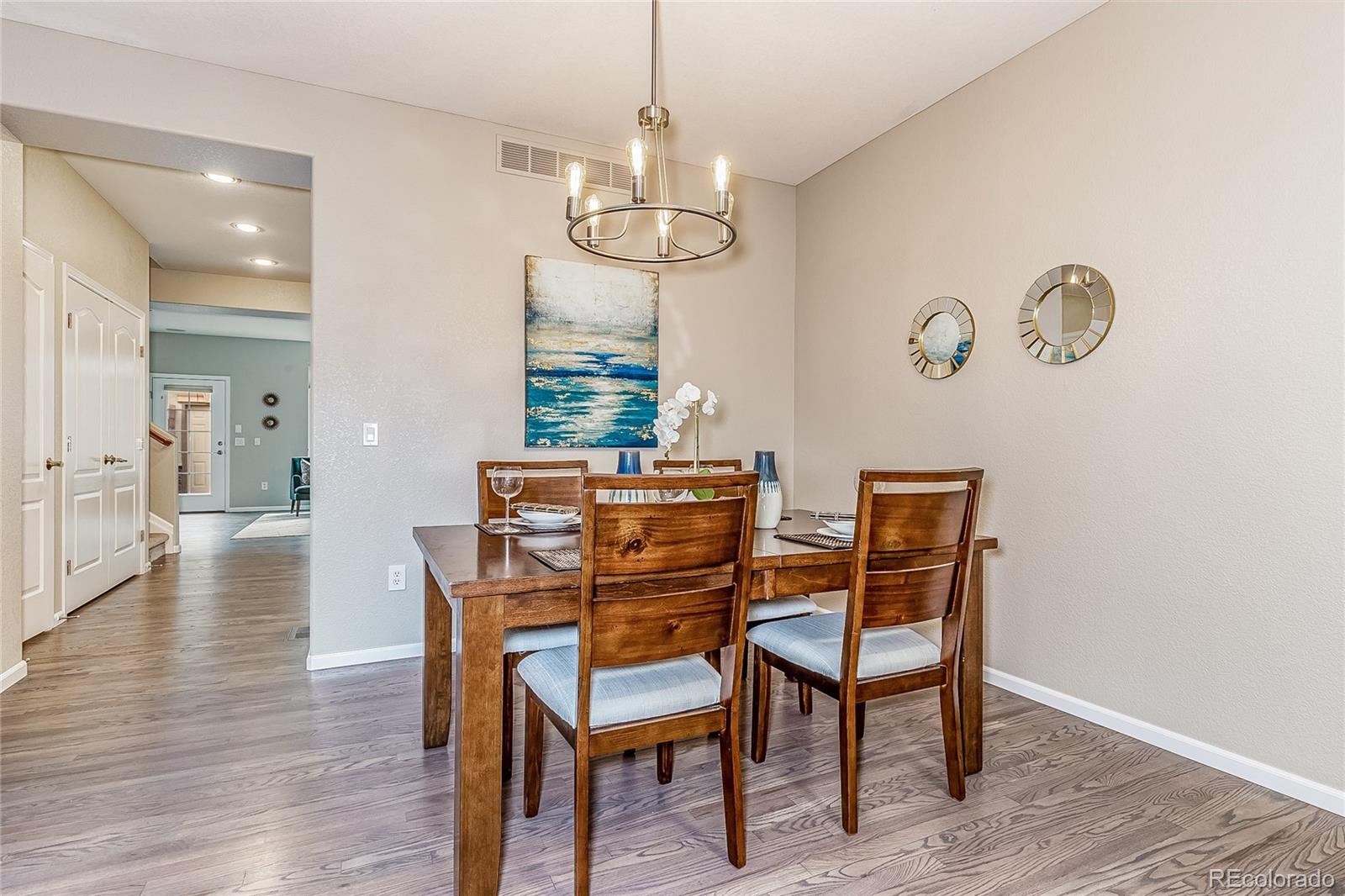 592 Brookhurst Avenue, Unit 26B Highlands Ranch, CO 80129 - Photo 9 of 19 a view of a dining room with furniture wooden floor and chandelier