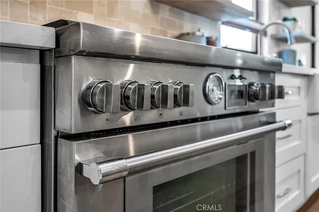 a kitchen with a stove a refrigerator and windows