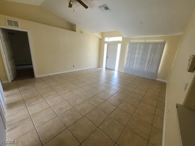 a view of a livingroom with wooden floor and a refrigerator