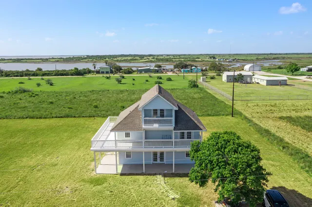 a view of a big house with a big yard and large trees