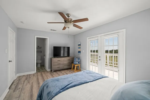 a bedroom with a balcony a bed and a flat screen tv