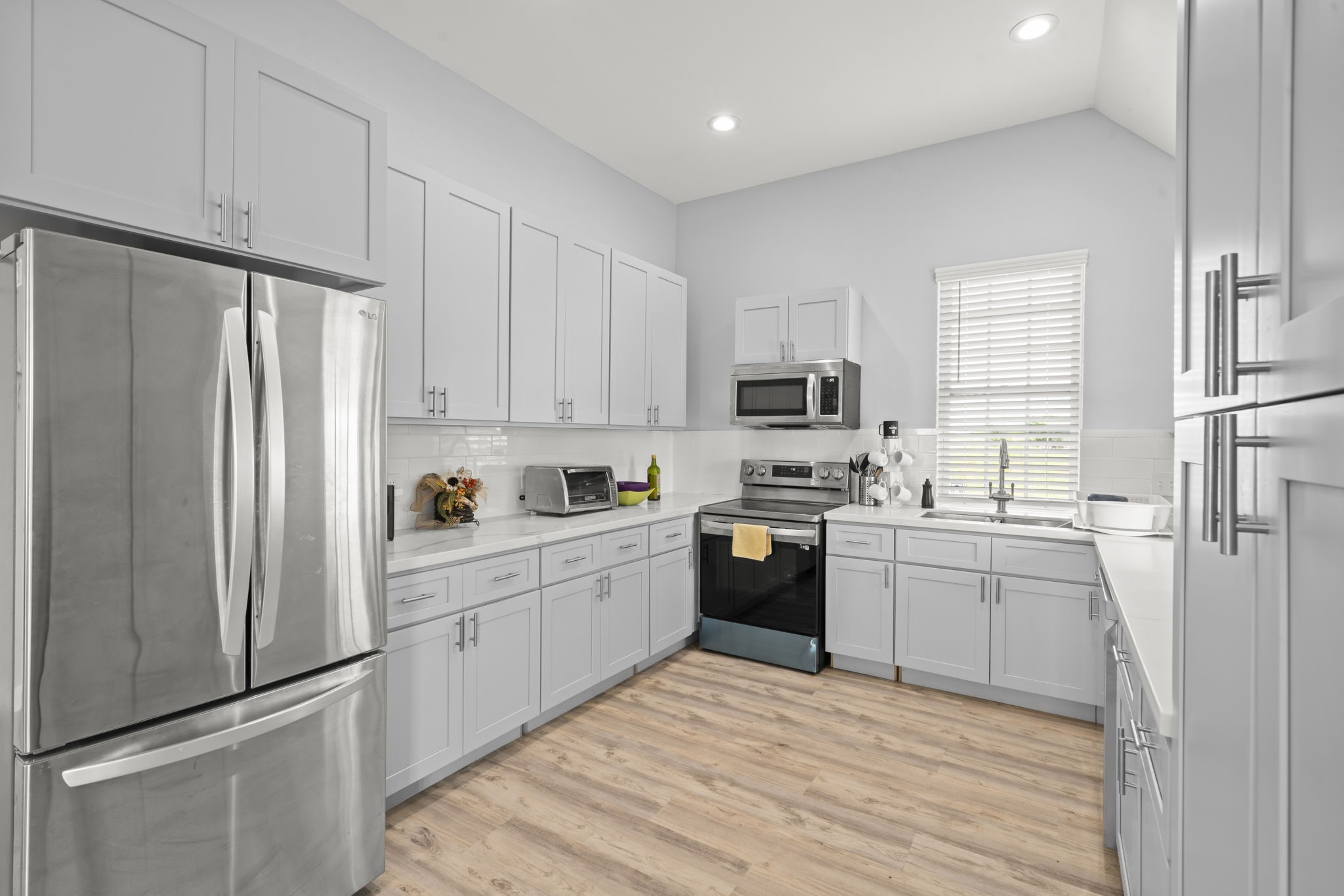 3582 County Road 476 Palacios, TX 77465 - Photo 6 of 31 a kitchen with white cabinets stainless steel appliances and a refrigerator