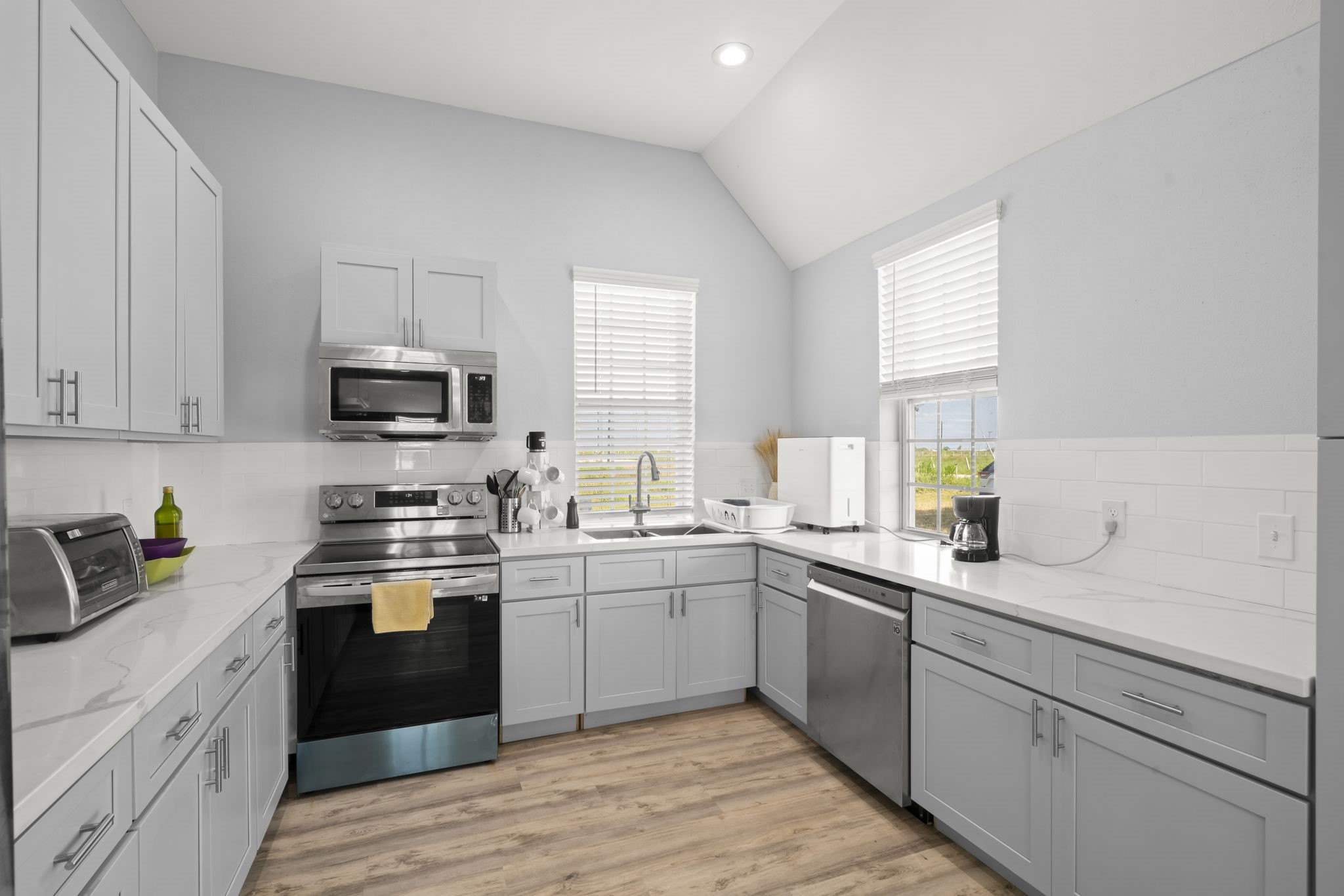 3582 County Road 476 Palacios, TX 77465 - Photo 8 of 31 a kitchen with a sink white cabinets and white appliances