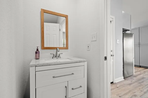 a bathroom with a sink vanity granite and a mirror