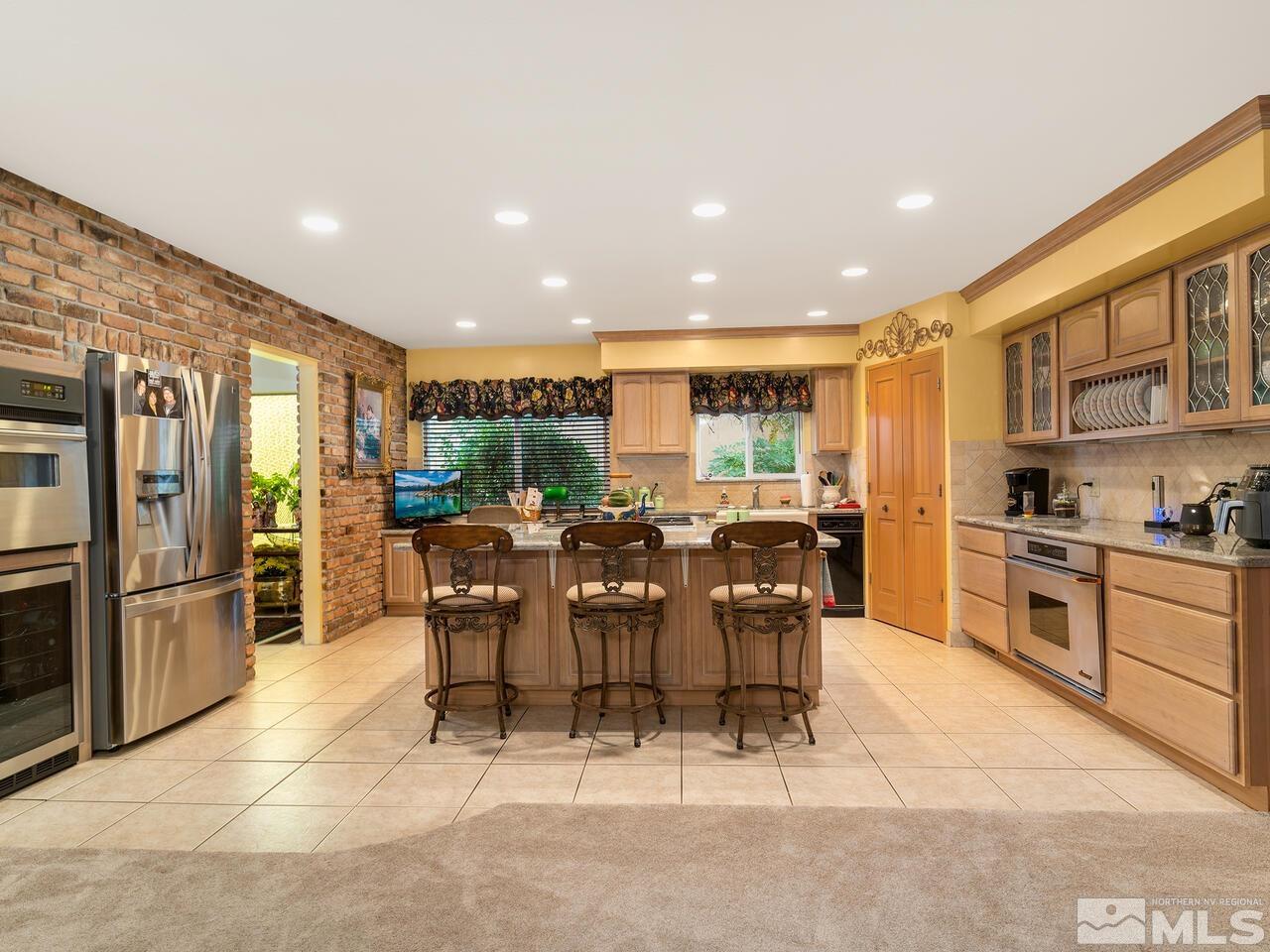 2125 Lakeside Drive Reno, NV 89509 - Photo 14 of 33 a large kitchen with stainless steel appliances kitchen island granite countertop a large center island and a refrigerator