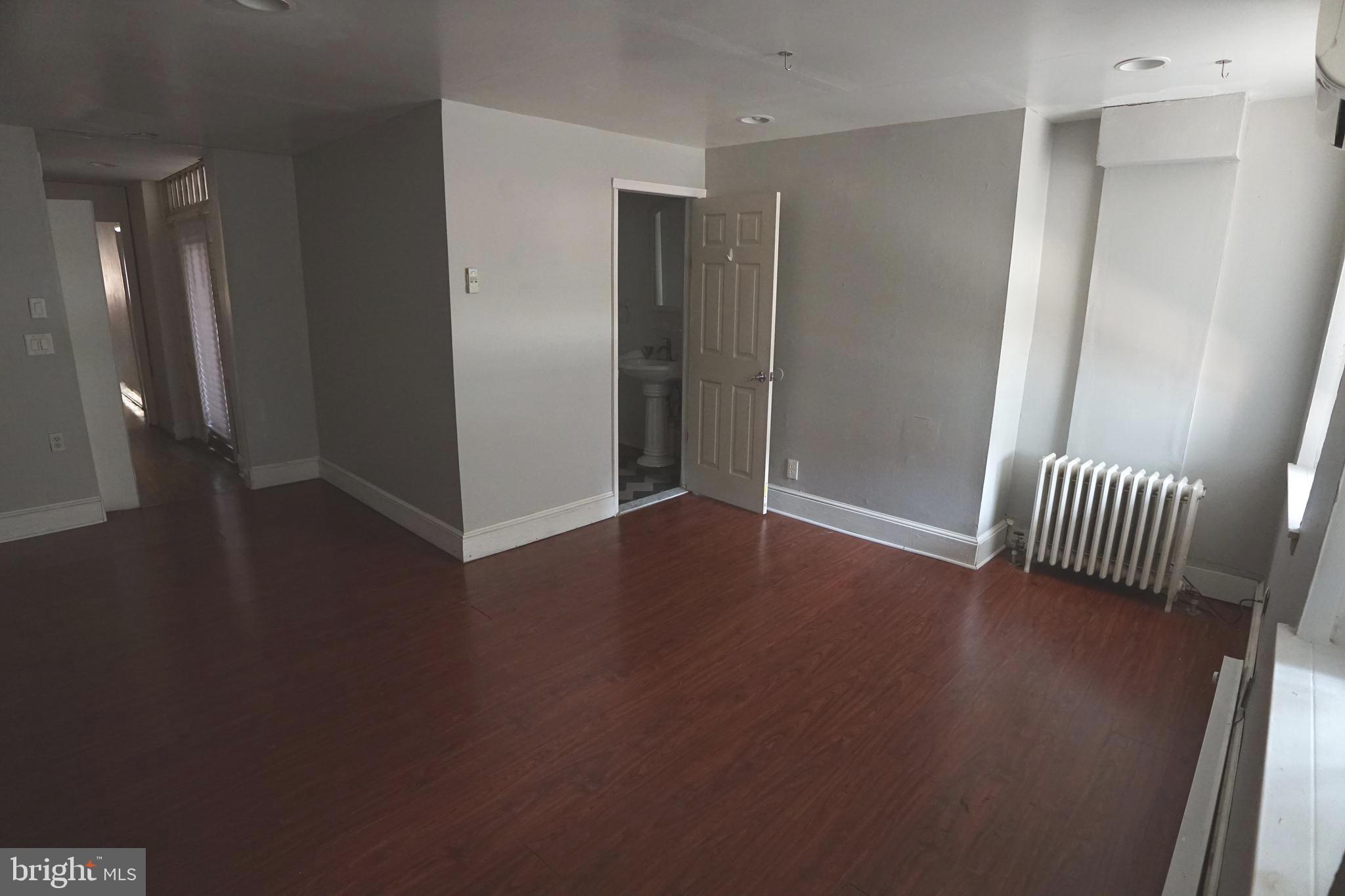 804 Cathedral Street, Unit 7 Baltimore, MD 21201 - Photo 11 of 22 an empty room with wooden floor and windows