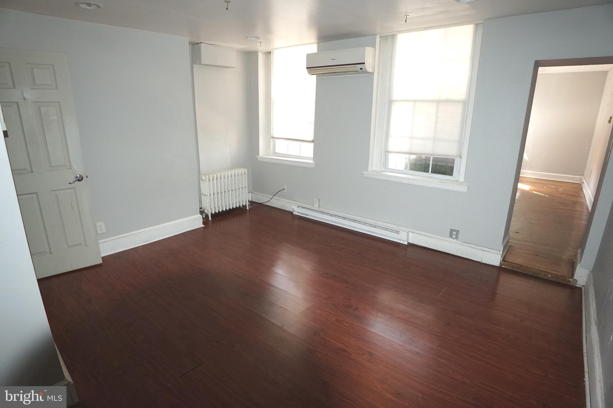 804 Cathedral Street, Unit 7 Baltimore, MD 21201 - Photo 10 of 22 an empty room with wooden floor and windows