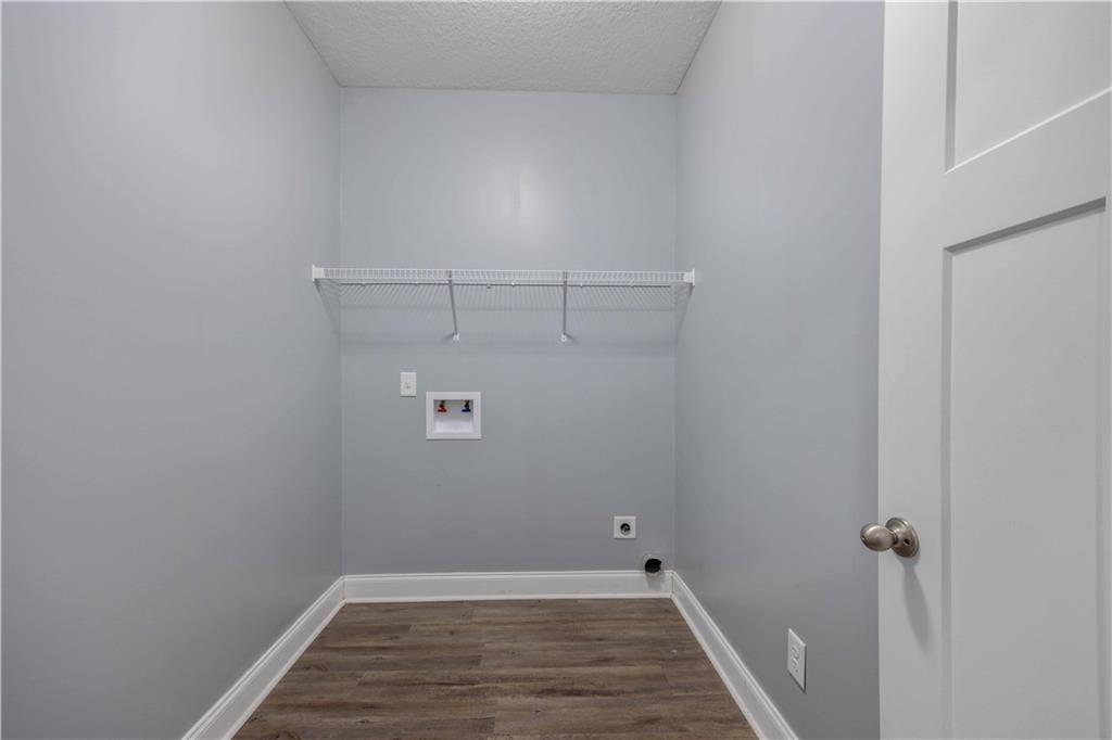 70 Apache Trail Fort Mitchell, AL 36856 - Photo 6 of 33 Laundry area featuring dark wood-type flooring, washer hookup, a textured ceiling, and hookup for an electric dryer
