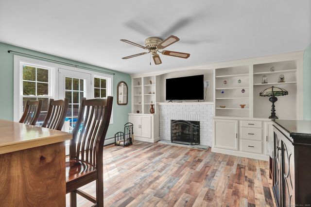 a view of a livingroom with a fireplace a chandelier and windows