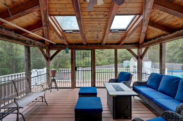 a view of a patio with couches chairs potted plants and wooden floor