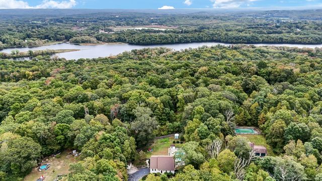 an aerial view of residential houses with outdoor space and trees