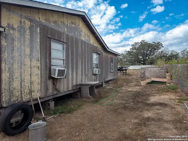 a backyard of a house with barbeque oven and barbeque oven