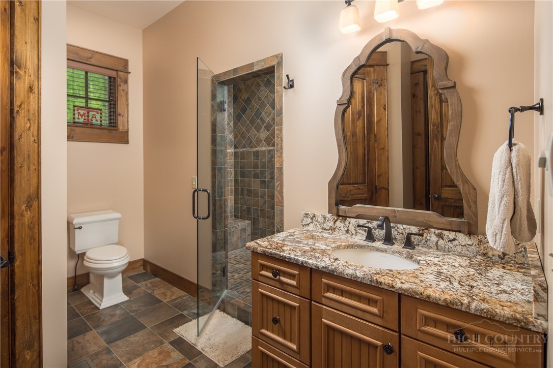 115 Passionflower Trail Boone, NC 28607 - Photo 25 of 50 a bathroom with a granite countertop sink toilet and shower