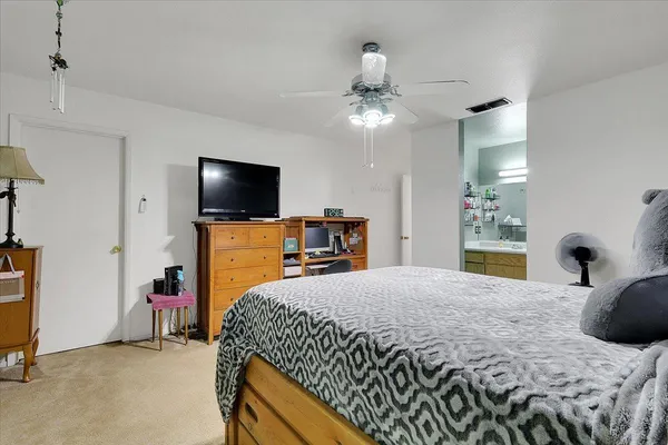 a bedroom with a bed and a flat tv screen on the dresser