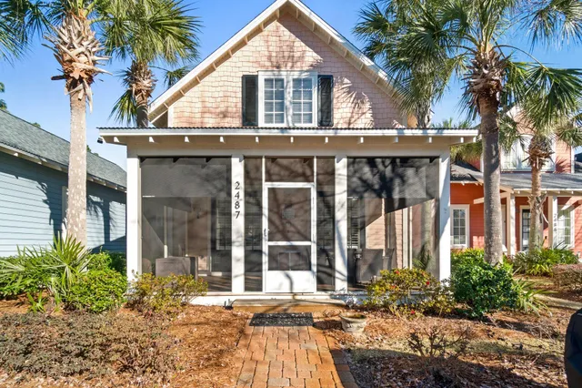 a view of a house with a yard and potted plants