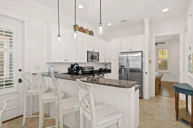 a kitchen with white cabinets and stainless steel appliances