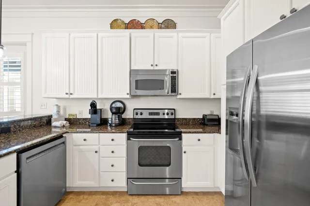 a kitchen with stainless steel appliances granite countertop a stove a sink and a refrigerator