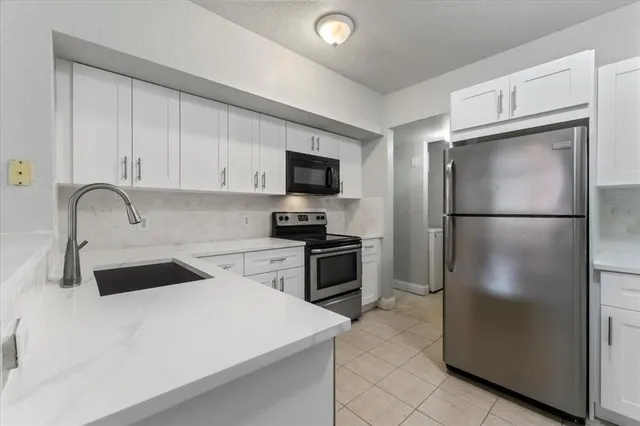 a kitchen with a refrigerator sink and cabinets