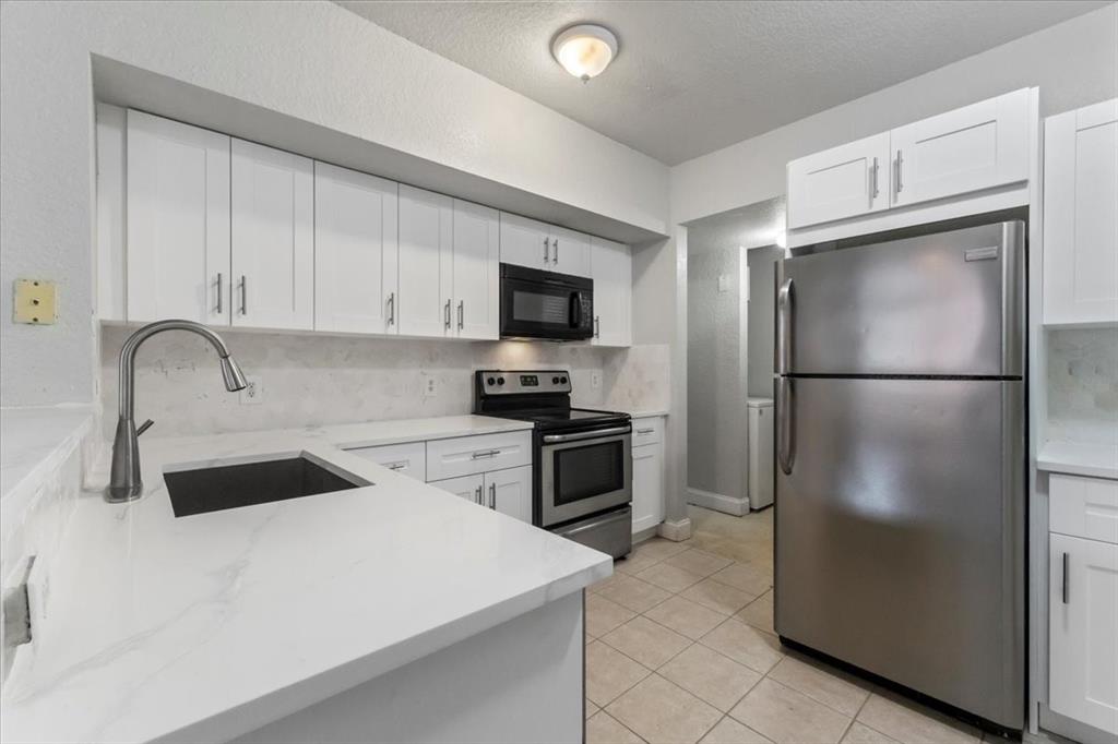 a kitchen with a refrigerator sink and cabinets