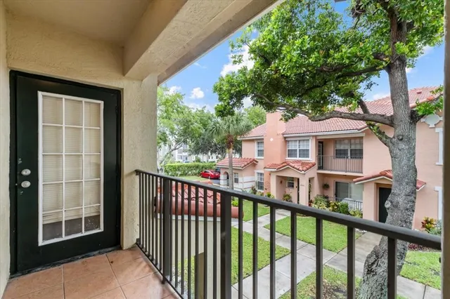 a view of a white house with a large window and wooden fence