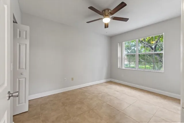 an empty room with windows and fan
