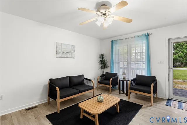 a living room with furniture a rug and a window