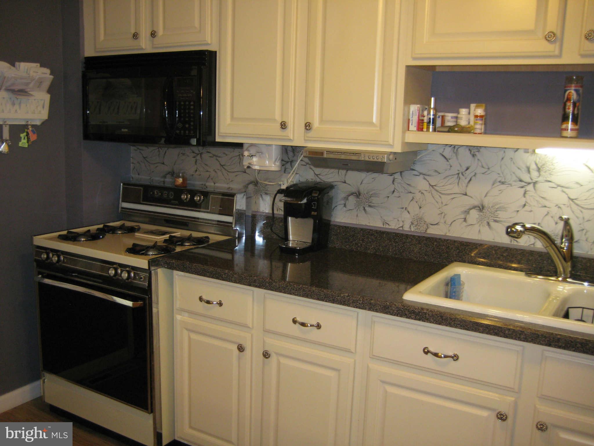 1780 Melbourne Road Baltimore, MD 21222 - Photo 14 of 25 a kitchen with granite countertop white cabinets and black appliances