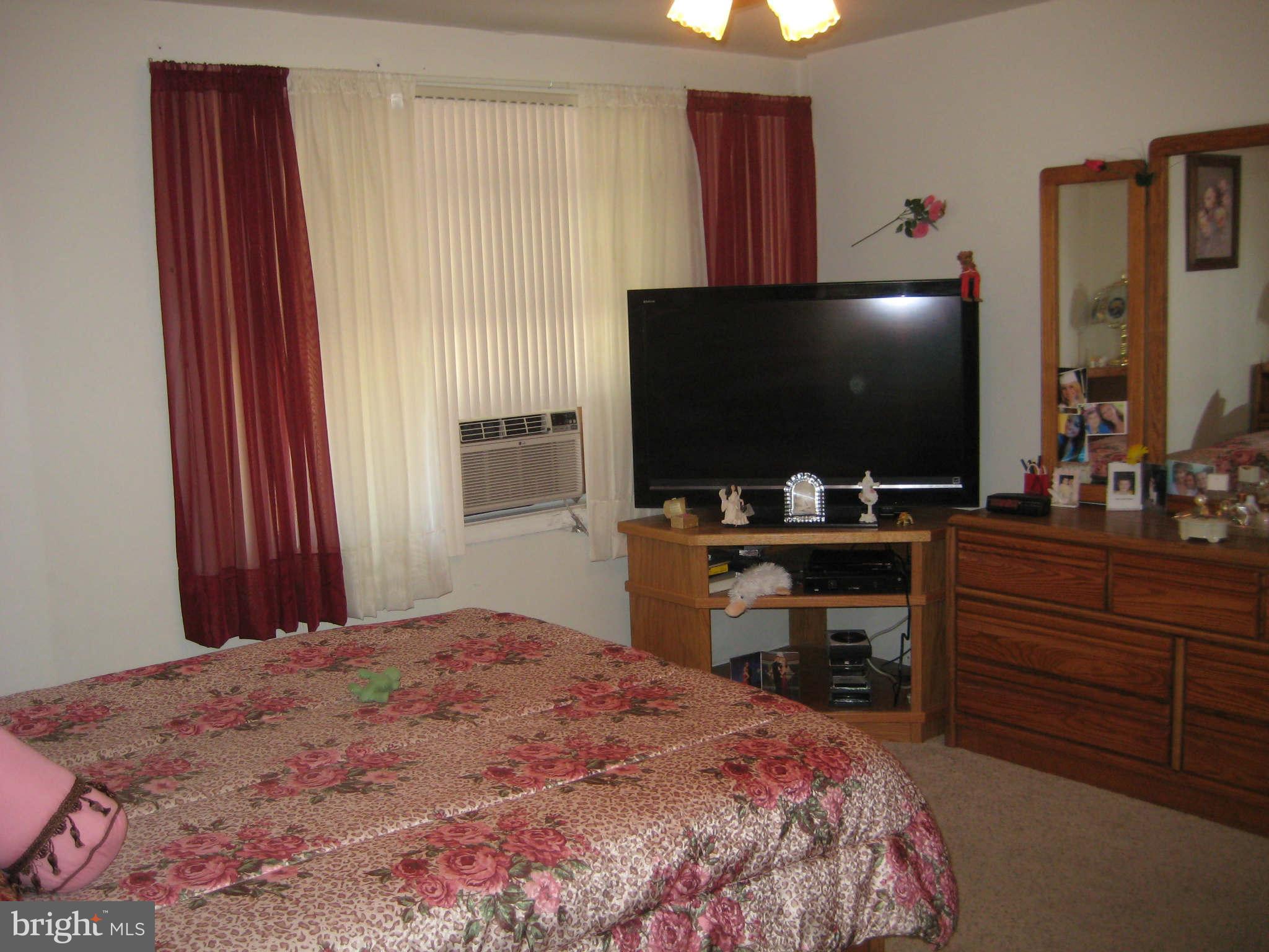 1780 Melbourne Road Baltimore, MD 21222 - Photo 18 of 25 a bedroom with a bed and a flat screen tv