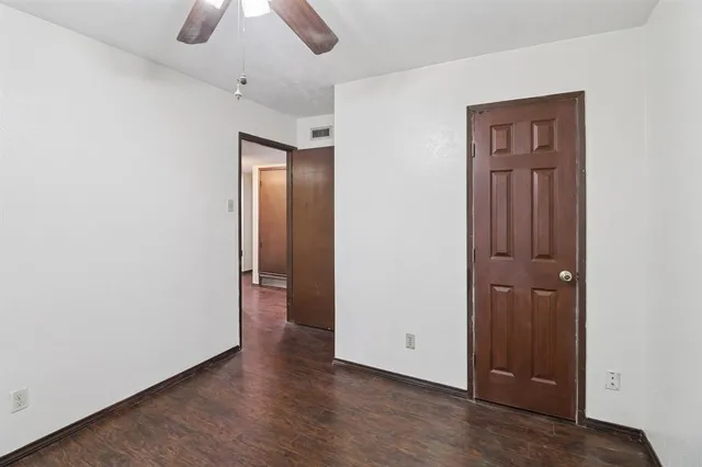 an empty room with closet and chandelier fan
