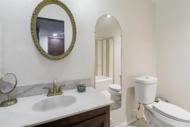 a bathroom with a toilet a sink and mirror