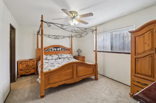 a bedroom with a bed next to a window