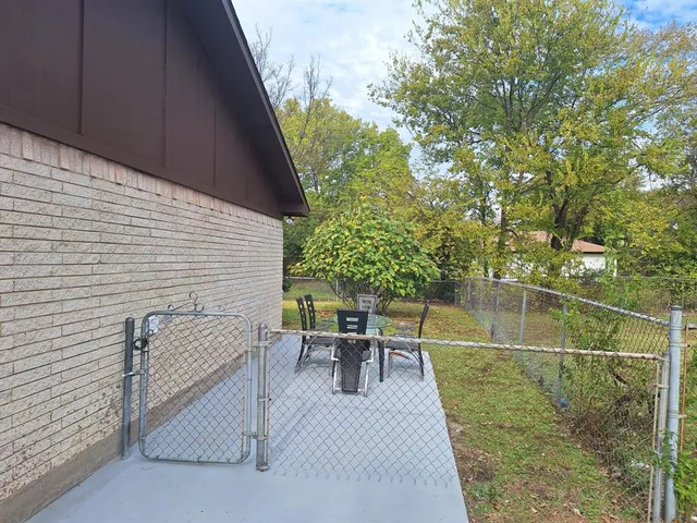 a view of a patio with a table chairs and backyard