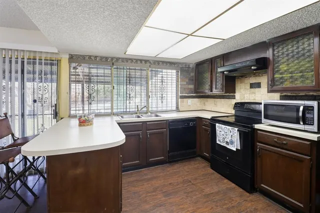 a kitchen with a sink and a stove top oven