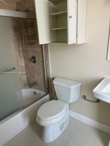 a white toilet sitting next to a bath tub and a shower