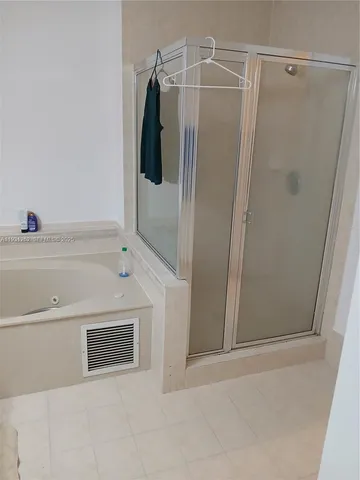 a bathroom with a shower and a bath tub