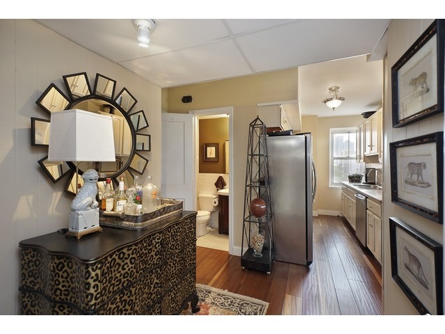 5555 North Sheridan Road, Unit 307 Chicago, IL 60640 - Photo 6 of 10 a kitchen view with granite countertop a refrigerator cabinets and wooden floor