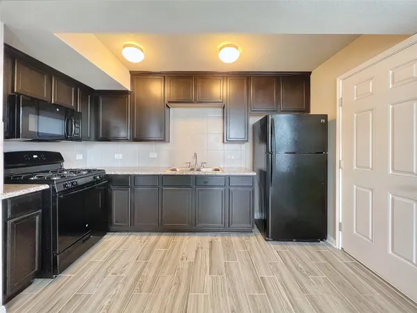 a kitchen with stainless steel appliances granite countertop a refrigerator and a stove