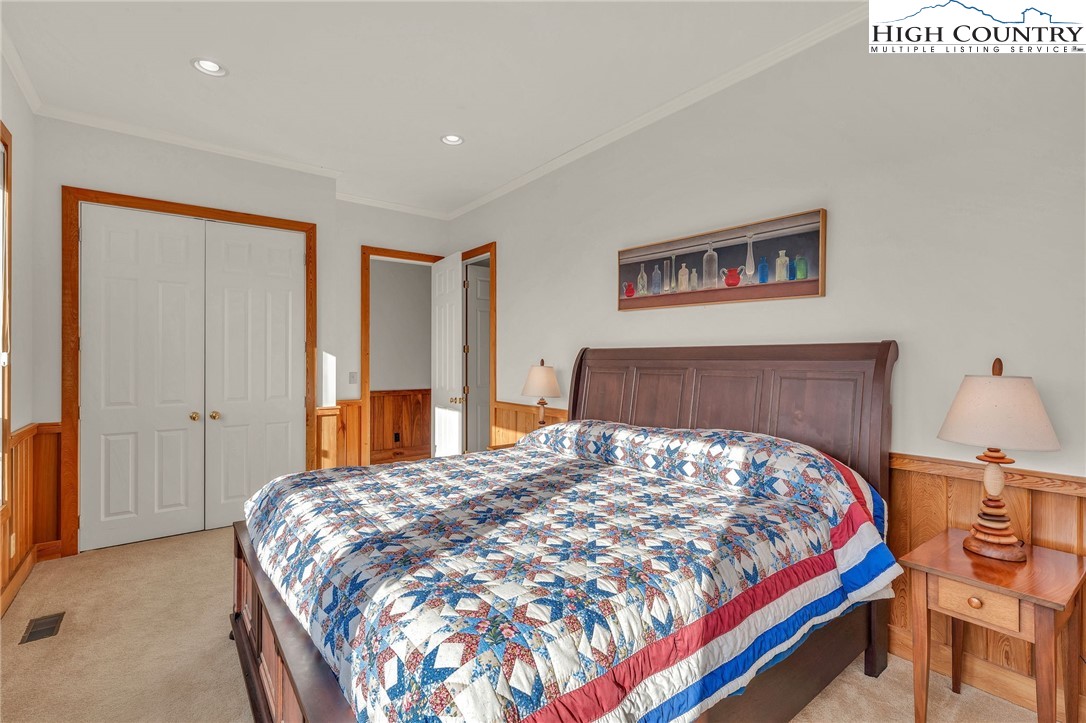 933 Thunder Ridge Lane Lenoir, NC 28645 - Photo 30 of 45 a bedroom with a large bed and a chandelier