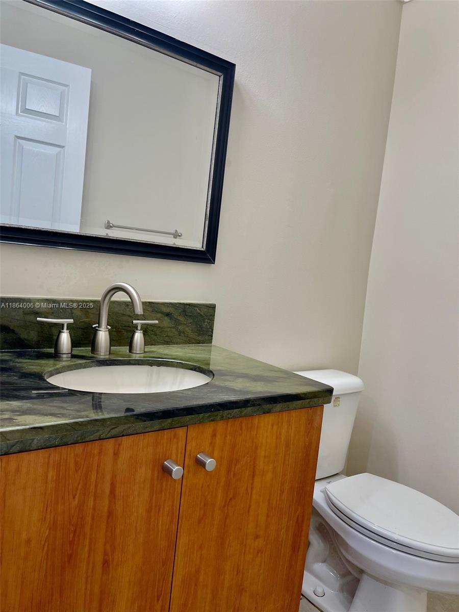 7362 Southwest 162nd Place Miami, FL 33193 - Photo 11 of 22 a bathroom with a granite countertop sink and a toilet