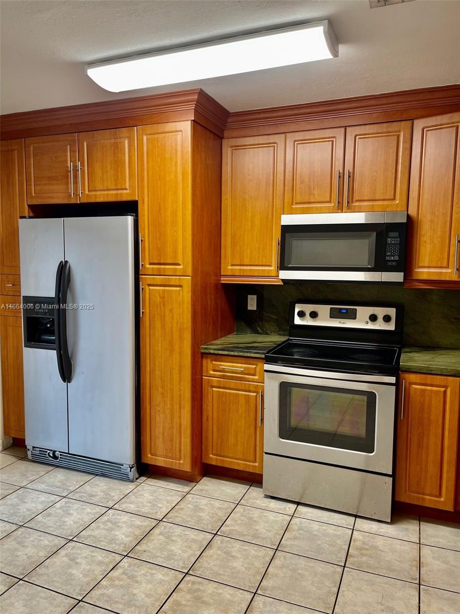 7362 Southwest 162nd Place Miami, FL 33193 - Photo 5 of 22 a kitchen with granite countertop cabinets stainless steel appliances and a window